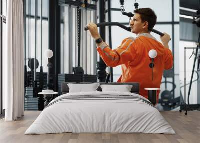 Young man working out training back muscles in the gym Wall mural