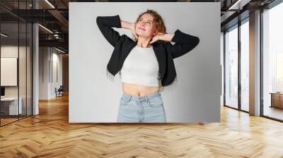 young woman with curly hair portrait against gray background Wall mural