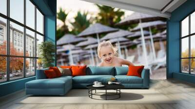 summer, childhood, vacation and people concept - happy little girl in swimwear having fun on beach Wall mural