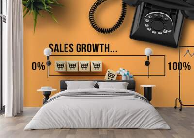 robot hand adding a cube with a shopping cart symbol to a growing graph with the message SALES GROWTH on orange background Wall mural