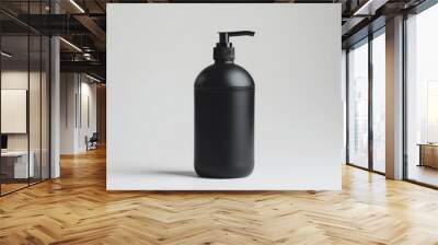 A black bottle of liquid sits on a white surface, ready for use or display Wall mural