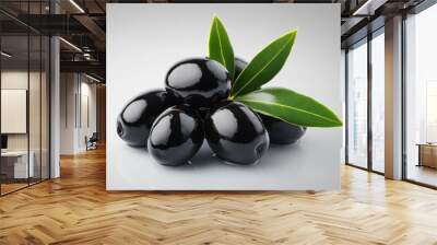 A collection of black olives surrounded by leaves on a white surface Wall mural