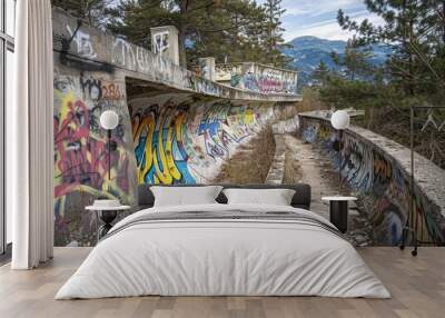 A colorful mural adorns the edge of a dense forest, blending urban and natural elements Wall mural