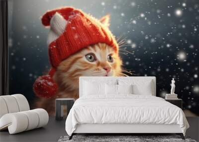 A cute small kitten wearing a red hat is pictured in the snow. This adorable image can be used to add a touch of cuteness and winter charm to various projects Wall mural