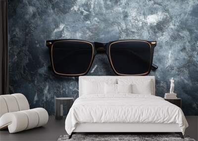 A pair of sunglasses lying on a table surface Wall mural