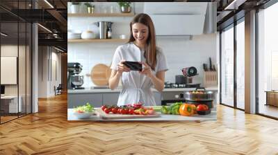 A person checking their tablet in a home kitchen Wall mural