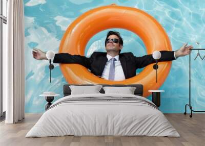 A person in a business suit floats on the surface of a pool, possibly relaxing or having fun Wall mural