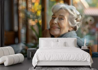 A senior woman sits comfortably on a couch in a cozy living room Wall mural