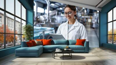 A woman in a lab coat is holding a tablet, possibly for medical or scientific use Wall mural