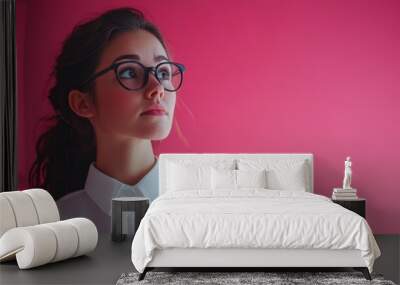 A woman in glasses typing on her laptop, focused on her work Wall mural