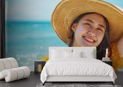 A woman relaxing on the beach wearing a straw hat, suitable for summer vacations or travel advertisements Wall mural