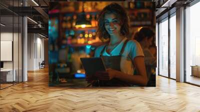 A woman stands in front of a bar, holding a tablet device Wall mural