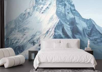 Aerial view of a mountain covered in snow with a clear blue sky in the background Wall mural