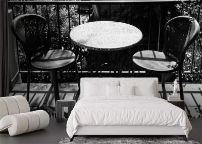 Two chairs and a table on a balcony with a view of the city or nature Wall mural