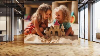 Two little girls are seen playing in the sand with a sand castle. This image can be used to depict childhood, friendship, summer activities, or beach fun. Wall mural