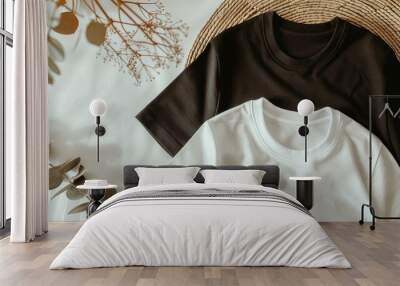 Two shirts sit on a bed, one white and one black Wall mural