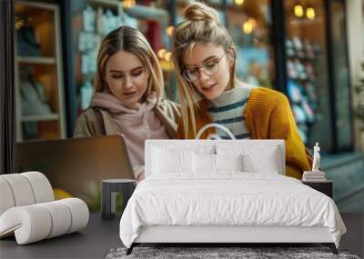 Two women viewing a laptop outdoors, possibly discussing or researching something Wall mural