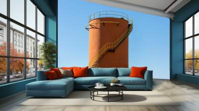 Metal oil storage tank used in oil industry in orange color and clear sky Wall mural