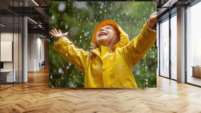 A joyful child in a yellow raincoat playing and smiling in the rain, embodying happiness and the simplicity of childhood enjoyment Wall mural