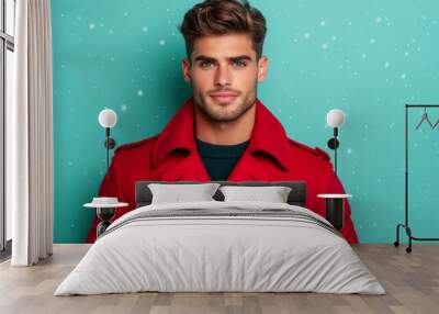 Handsome male model wearing a festive red trench coat with snowflakes on a cool white-to-emerald green gradient background  Wall mural