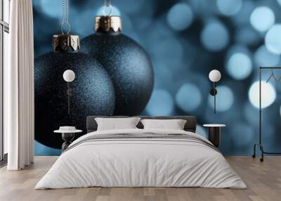 Modern matte black Christmas balls hanging on a sleek cool toned blurred background with subtle blue highlights  Wall mural