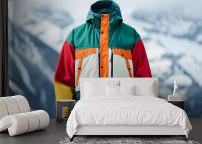 Upcycled ski jacket with multiple colors and textures, displayed against a backdrop of snowy mountains  Wall mural