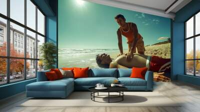 Wide-angle view of a lifeguard performing CPR on a beach after a near-drowning incident  Wall mural