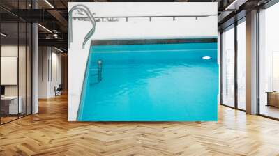 Beautiful blue color swimming pool in winter, poolside covered with white soft snow.  Wall mural