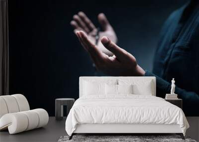 Muslim man praying on dark background Wall mural