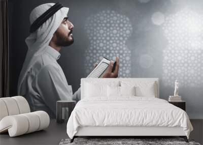 Religious arab muslim man reading holy quran Wall mural