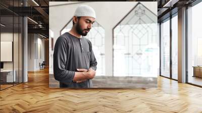 Religious muslim man praying in mosque Wall mural