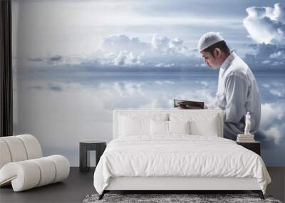 Religious muslim man reading holy quran Wall mural