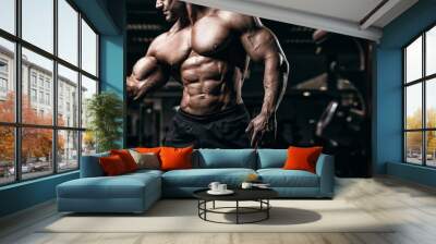 Muscular man bodybuilder training in gym and posing. Fit muscle guy workout with weights and barbell Wall mural