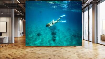 Woman snorkeling underwater at a tropical island resort Wall mural