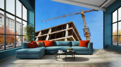 Crane and concrete building under construction. Construction site background Wall mural