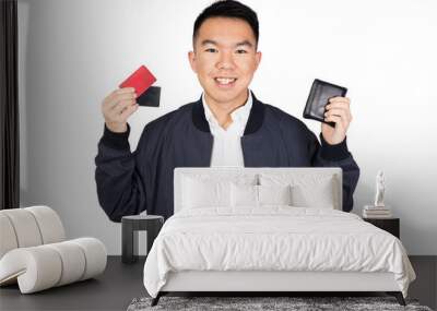 A young man holding up his wallet and two credit cards Wall mural