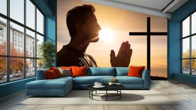  A man in prayer, silhouetted against a background with a simple cross. _1(91) Wall mural