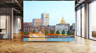 Savannah Georgia USA, skyline of historic downtown at sunset with illuminated buildings and steam boats Wall mural