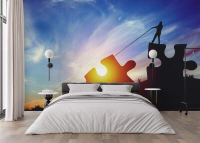 People silhouettes putting puzzle pieces together on sunlight background Wall mural