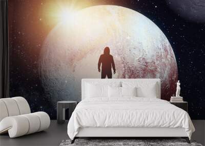 Silhouette of a man standing on the top of a mountain against the backdrop of the planet. Elements of this image furnished by NASA Wall mural