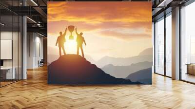 Silhouette of people team with trophy at sunset evening sky background. Wall mural