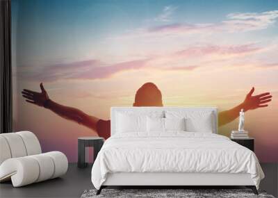 Young man standing outstretched at sunset. Victory Wall mural