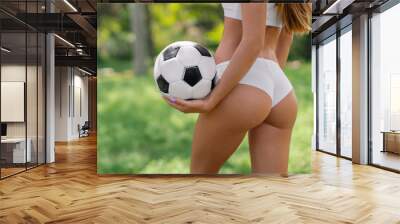 Young sexy girl in white sportswear with a soccer ball Wall mural