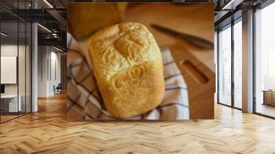 A piece of white homemade bread lies on the table in a wooden village house. Wall mural