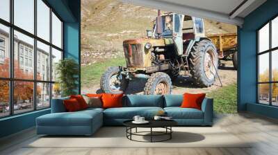 An old vintage tractor on a farm. Non-working condition, rust. Wall mural