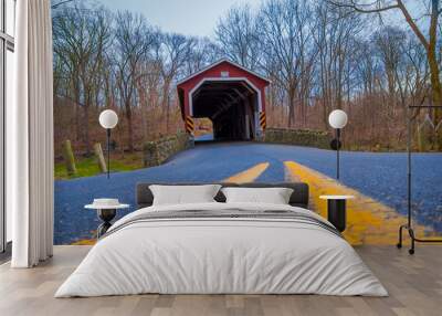 Close up of the street with yellow line at outdoors with a red covered bridge located inside of the forest in a cloudy day in Lancaster Wall mural