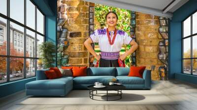 QUITO, ECUADOR - AUGUST, 30 2017: Young indigenous woman wearing a typical andean clothes, holding in her hand a colorful blanket Wall mural