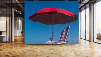 Two beach chairs and an umbrella with a set of mate. Wall mural