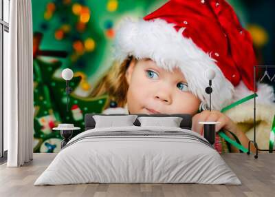 Happy small girl in santa hat have a christmas Wall mural