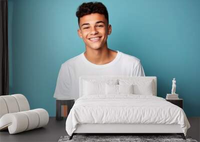 smiling young man in white shirt against blue background, Wall mural